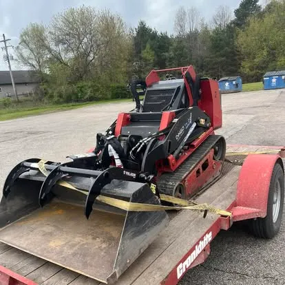 Compact track loader with grapple attachment used for brush cleanup, Manistee, MI
