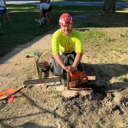 Logan, owner of Up North Tree Care in Manistee, MI, with chainsaws after a job